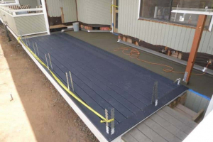 Trex decking on portion of balcony outside foundation installed. Decking slotted to accommodate post base straps.