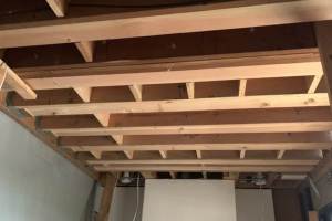 New cantilevered beams and 2 by 12 joists installed above fireplace den