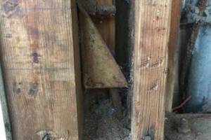 Termite decay at post / trimmer and pressure treated framing bogom plate adjacent to garage door. Existing steel hardware ( hold down ) connecting wood framing to concrete foundation at this location. Important detail in California and areas vulnerable to earthquakes.