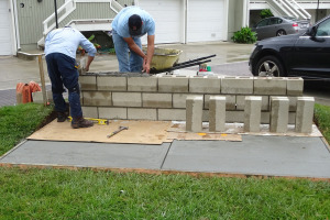 Masonry blocks for patio wall being installed